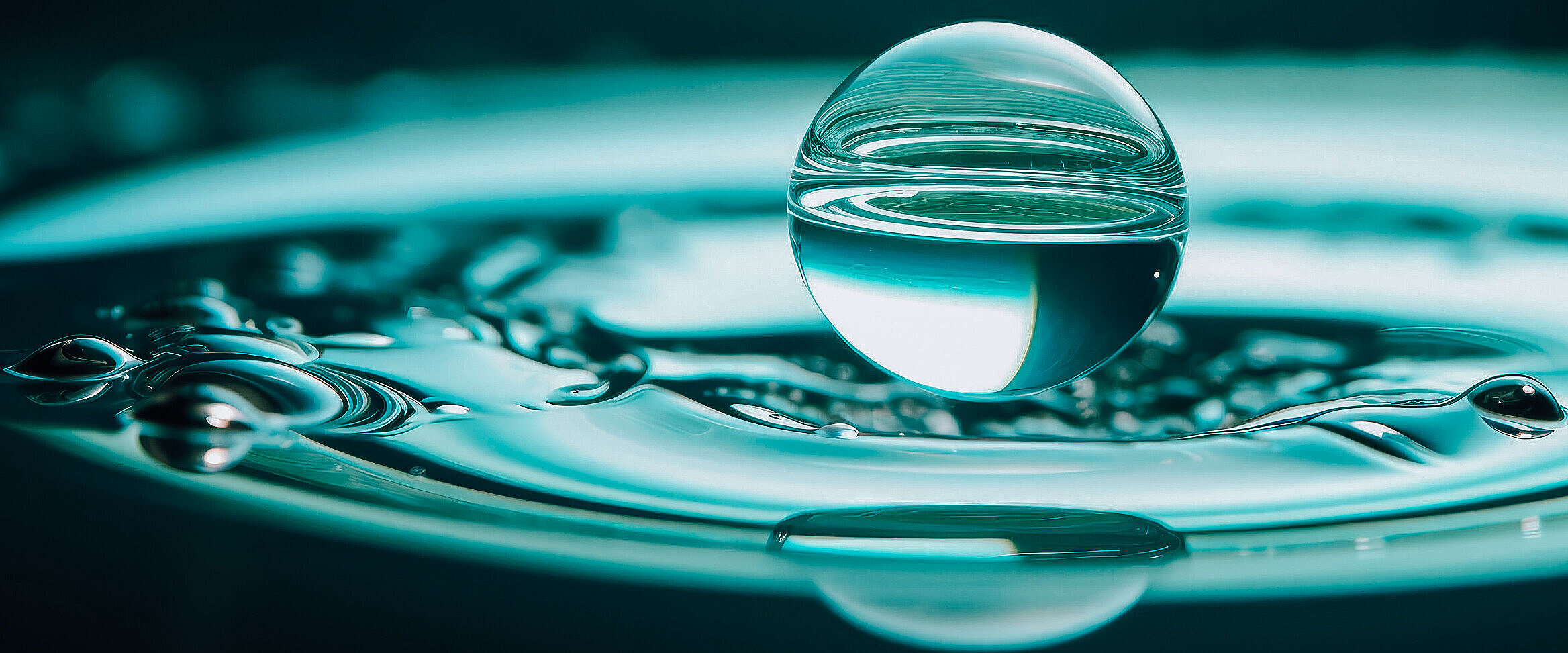 Kugelrunder Wassertropfen auf einem Wasserstrudel