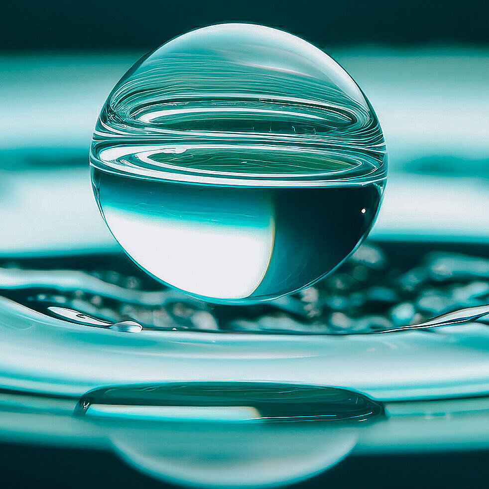 Kugelrunder Wassertropfen auf einem Wasserstrudel